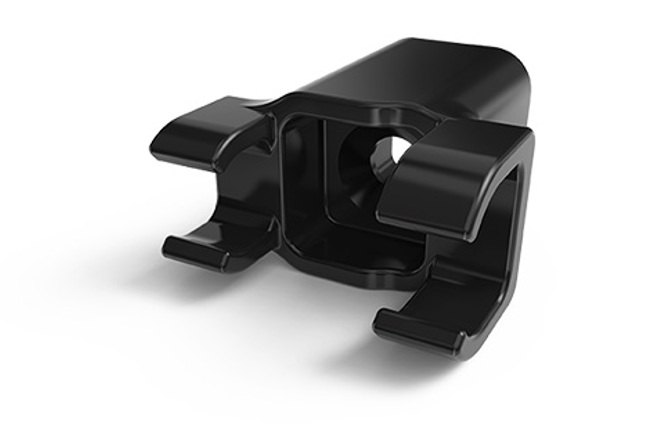 Black round plastic part with twin clasp-like extensions.