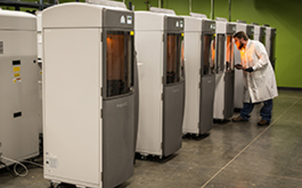 technician examining 3d printed parts in protolabs 3D printers