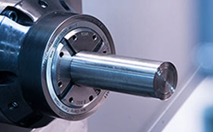 Metal rod stock is firmly fixtured in a high-speed CNC lathe before turning and milling begin