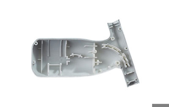 Light gray molded plastic piece with intricate internal structures.