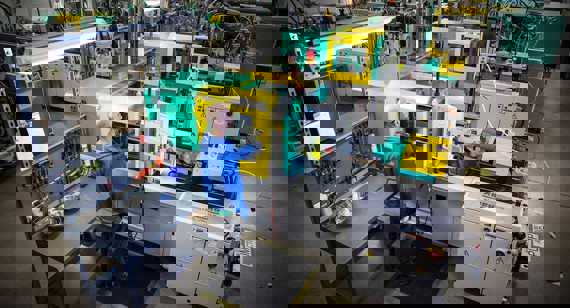 operatore davanti alla pressa per stampaggio di gomma siliconica liquida