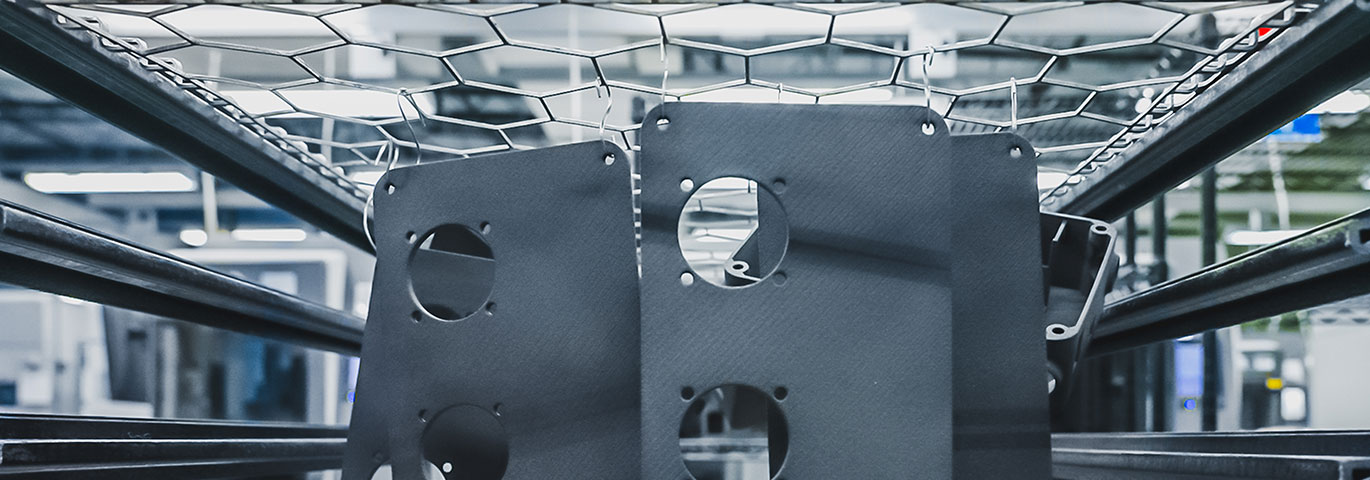Industrial setting with metal structures and mesh, showcasing black machinery components.