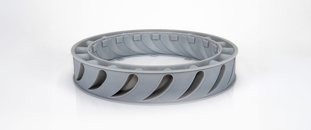 Gray plastic stator core prototype on a white background.