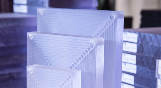 Stacked translucent acrylic blocks with labels, set against a blurred background.