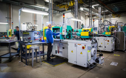 technician examining injection molding block