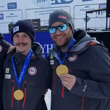 Snowboarders holding gold medals
