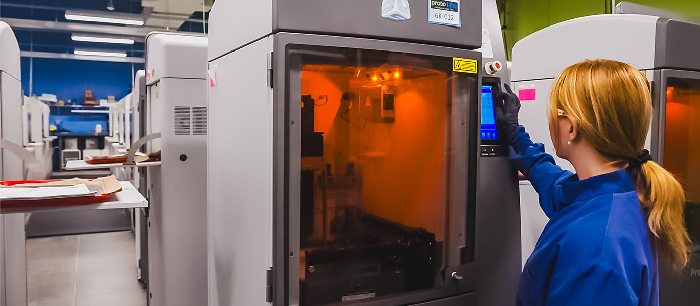Technician in blue operates a lit-up machine.